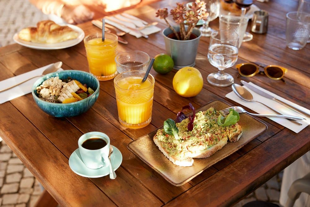 Toast, fruit, juice and coffee on a breakfast table.