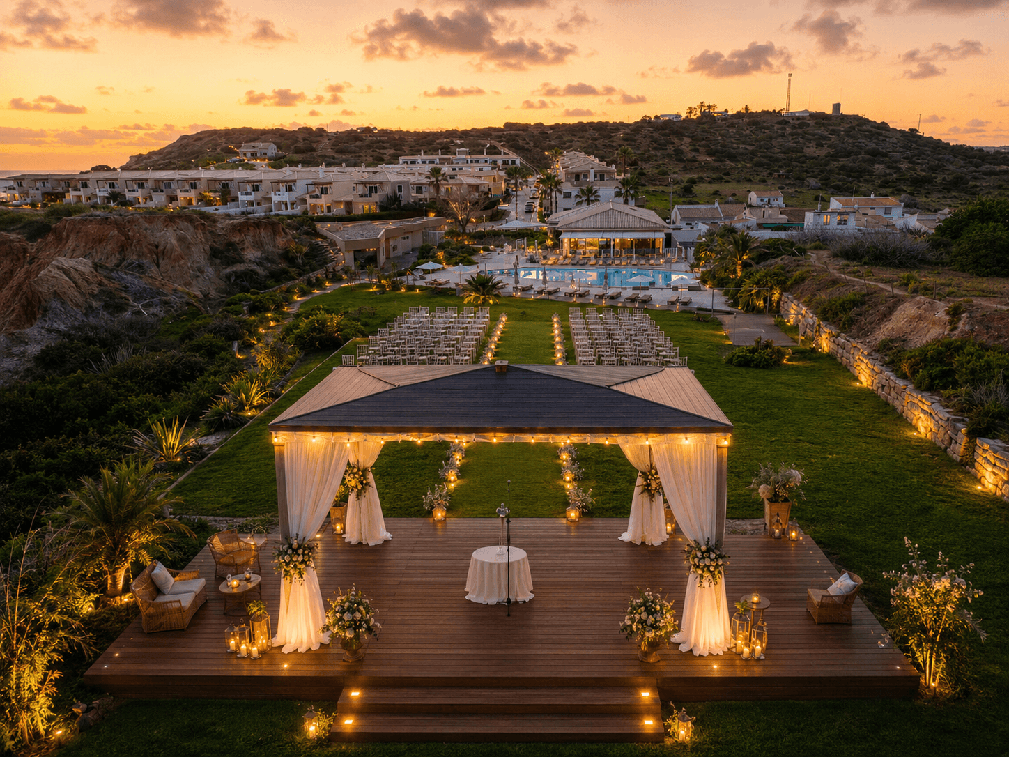 Ceremony setting with flowers, chairs and lights at sunset.